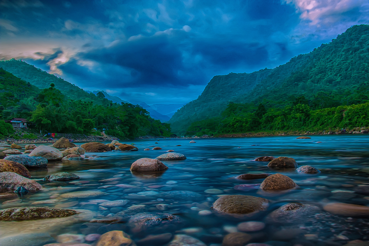 Uma pessoa de braços abertos, em um cenário de montanhas ao nascer do sol, simbolizando adoração e liberdade.